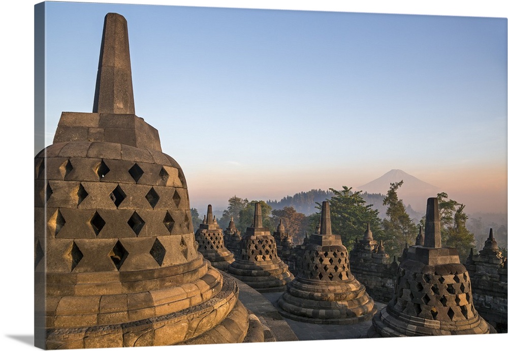 Indonesia, Java, Borobudur. Early morning sun shines on the dormant Stratovolcano, Mount Sumbing, with the famous 9th cent...