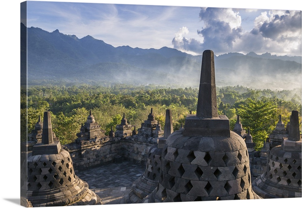 Indonesia, Java, Borobudur. The famous 9th century Buddhist temple at Borobudur with the Menoreh Mountain Range in the dis...