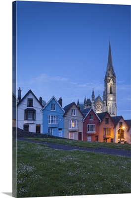 Ireland, Cobh, Deck of Cards hillside houses and St. Colman's Cathedral, dusk