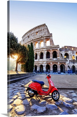 Italy, Rome, a red Vespa motorbike in front of Colosseum at sunrise