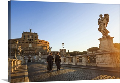Italy, Rome, two monks walking at Mausoleum of Hadrian at sunrise