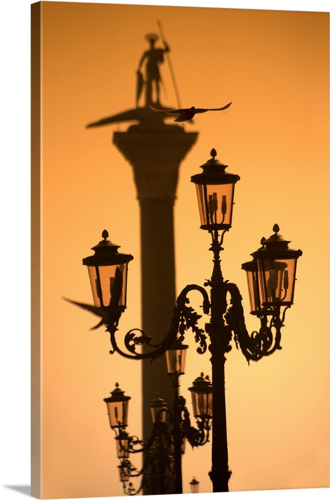 Italy, Veneto, Venice, From Piazza San Marco towards Bacino San Marco, the statue of St.Mark, with lamp posts in the foreg...