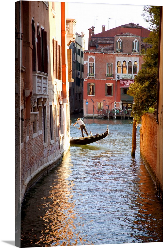 Italy, Veneto, Venice. A gondolier rowing his gondola on the Grand Canal. UNESCO.