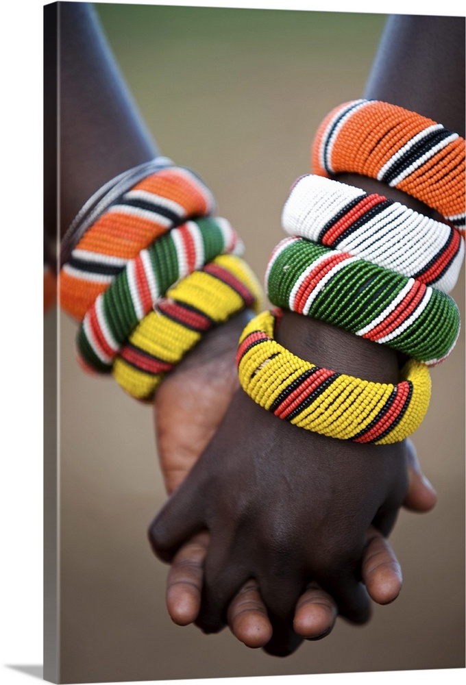 Kenya, Laikipia, Ol Malo. A Samburu boy and girl hold hands at a dance in their local manyatta.