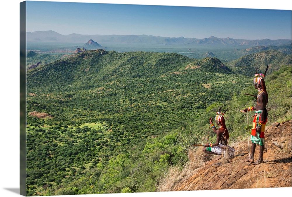 Kenya, Kirimun, Samburu County. Two Samburu warriors pause to look for livestock on the edge of the Kirimun escarpment.