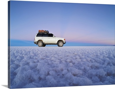 Landcruiser on the Salar de Uyuni, the largest salt flat in the world at sunset, Bolivia