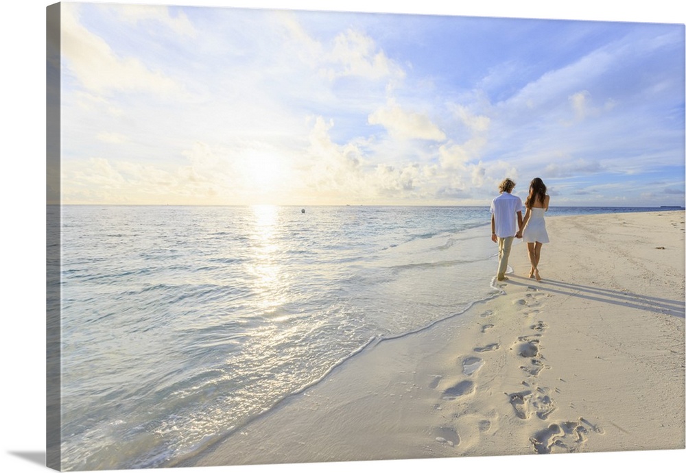 Maldives, South Ari Atoll, Thudufushi Island, Diamonds Thudufushi Resort, couple walking on the beach.