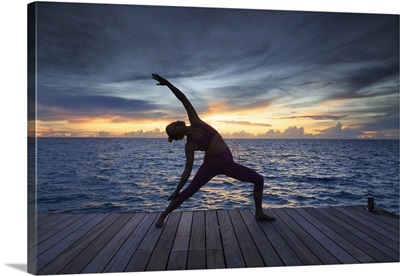 Maldives, South Ari Atoll, Thudufushi Island, woman practicing Yoga at sunset