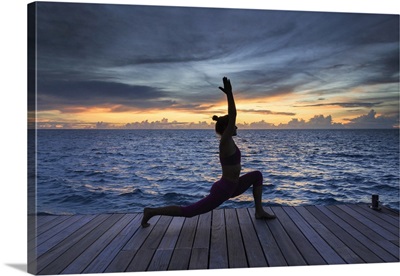 Maldives, South Ari Atoll, Thudufushi Island, woman practising Yoga at sunset