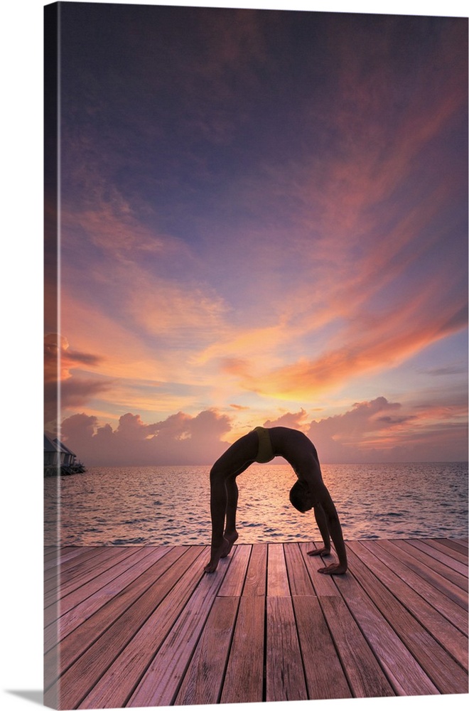 Maldives, South Ari Atoll, Thudufushi Island, Diamonds Thudufushi Resort, man practising Yoga at sunset.