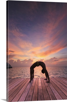 Man practising Yoga at sunset, Diamonds Thudufushi Resort, Maldives