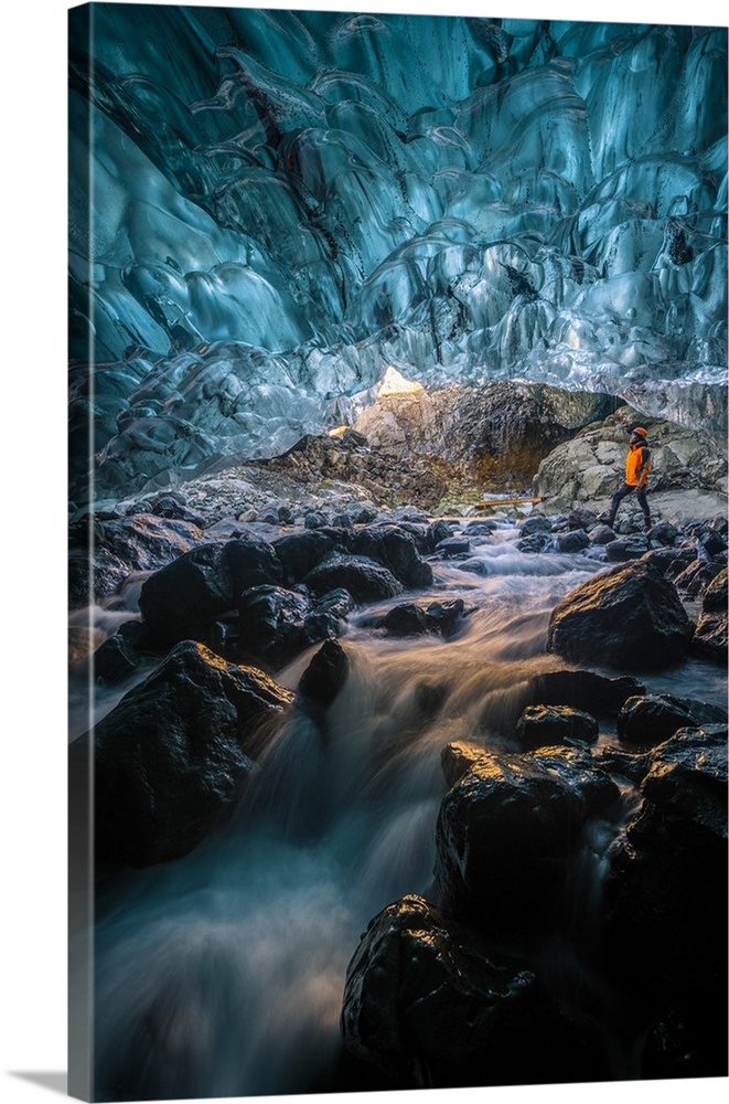 Vatnajokull glacier, Eastern Iceland, Iceland, Northern Europe. Man standing still at the entrance of a crystal ice cave i...