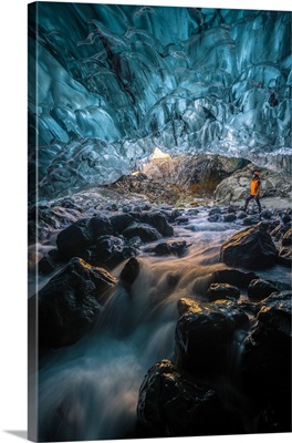 Man standing at the entrance of a a crystal ice cave in winter, Vatnajokull, Iceland