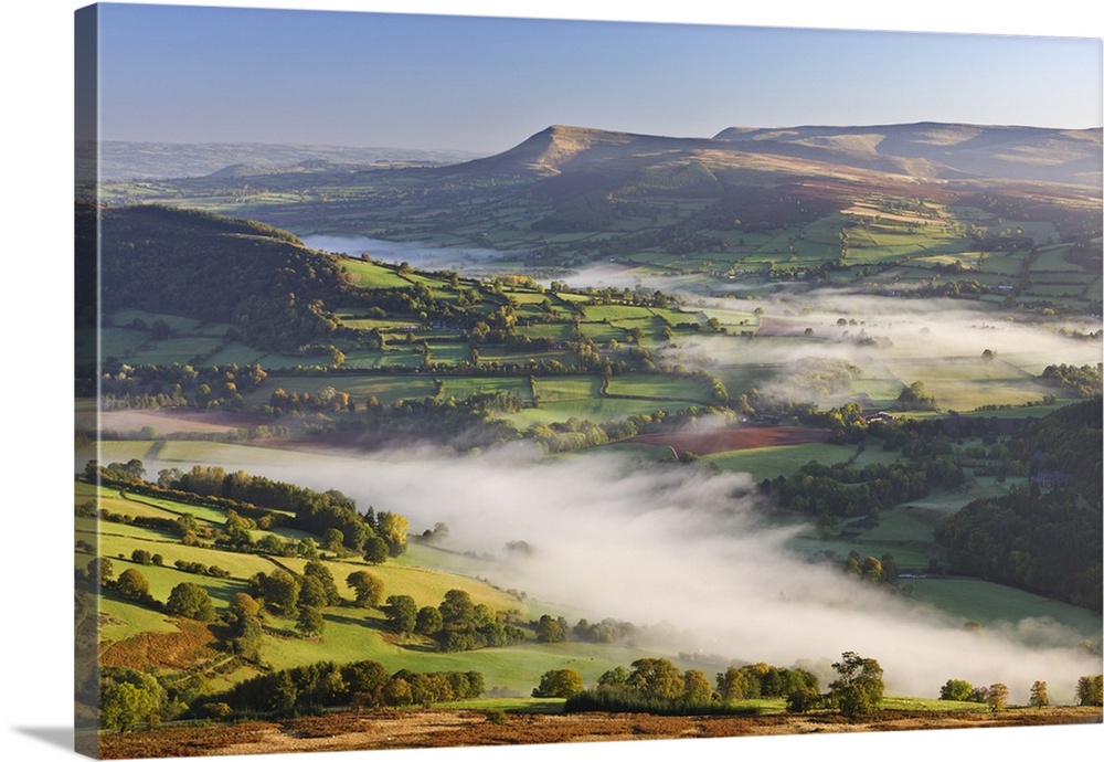 Mist covered rolling countryside backed by the Black Mountains, Brecon Beacons National Park, Powys, Wales, UK. Autumn, Oc...