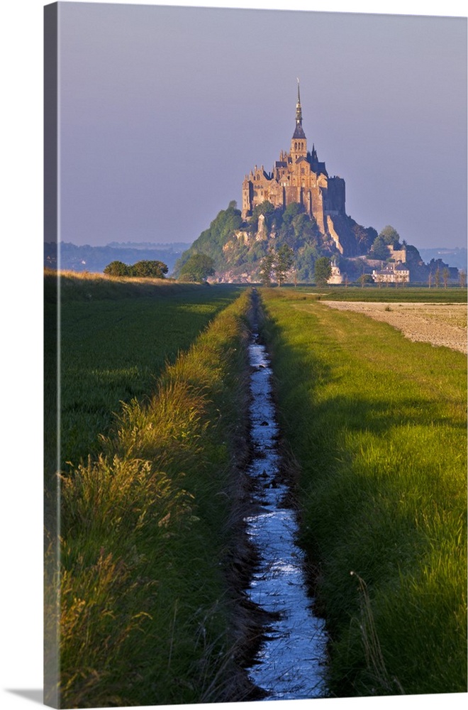 Mont Saint Michel at sunset viewed from a polder and a drainage channel, Le Mont Saint Michel, Basse Normandie, France.
