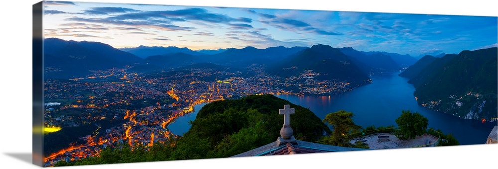 Elevated view over Lugano from Monte San Salvatore illuminated at Dusk, Lake Lugano, Ticino, Switzerland.