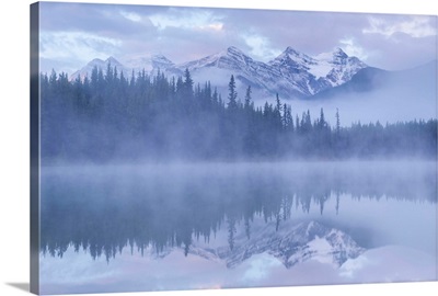 Mountains reflect in misty Herbert Lake, Banff National Park, Alberta, Canada