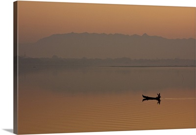 Myanmar, Burma, Amarapura, A fisherman paddling across Taungthaman Lake at sunrise