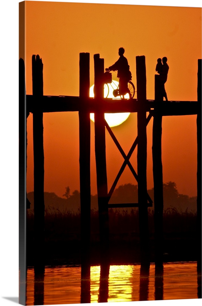 Myanmar, Burma, Amarapura, Taungthaman Lake, U Bein's Bridge. A family walking home at sunset over U Bein's Bridge, over 2...