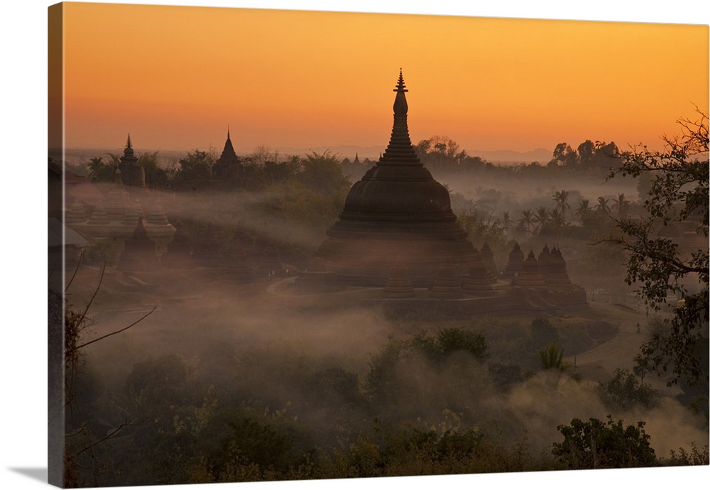 Myanmar, Burma, Mrauk U. Evening mist and smoke from village cooking fires swirl around Ratanabon Paya, Mrauk U, Rakhine S...