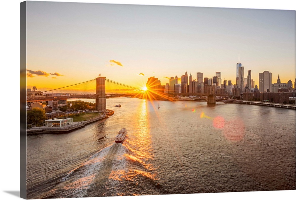 USA, New York, Lower Manhattan Skyline and Brooklyn Bridge over East River at Sunset.