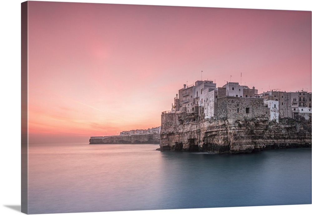 Old town of Polignano a Mare built on rocky cliffs at sunrise, Bari province, Apulia region, Italy.