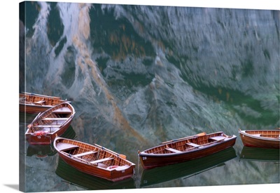 Row Boats Floating In The Braies Lake, Mountains Reflecting In Water, Dolomites, Italy