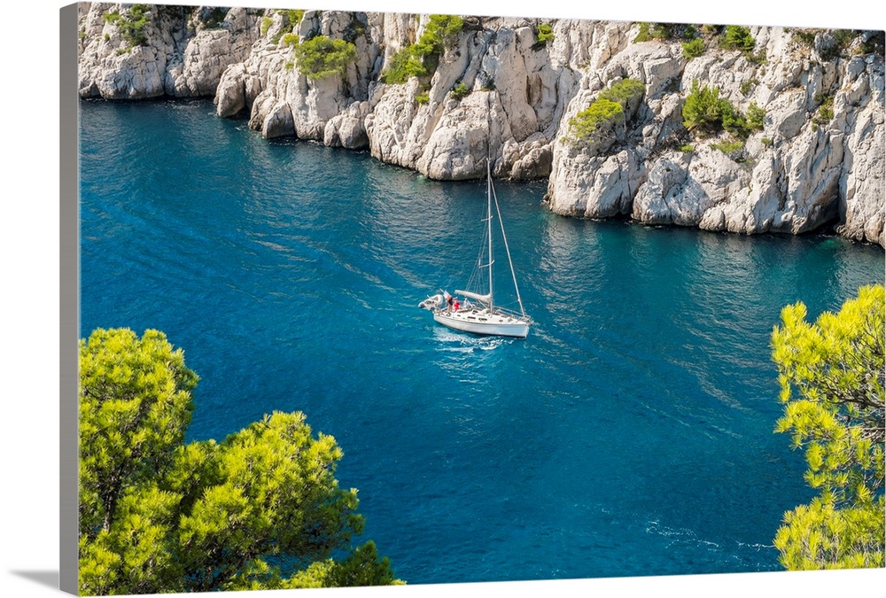 Sailboat passing through emerald blue water of Calanque de Port-Pin, Cassis, Bouches-du-Rhone, Provence-Alpes-Cote d'Azur,...