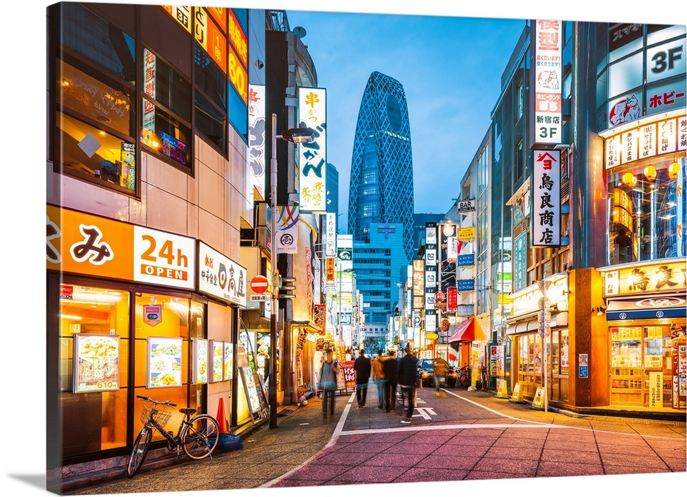 Shinjuku, Tokyo, Kanto region, Japan. Illuminated neon signs at dusk and Cocoon Tower in the background.