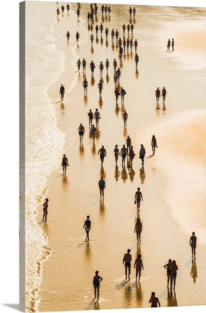 Spain, Basque Country, San Sebastian (Donostia). Tourists walking on the shoreline of the Beach of La Concha.
