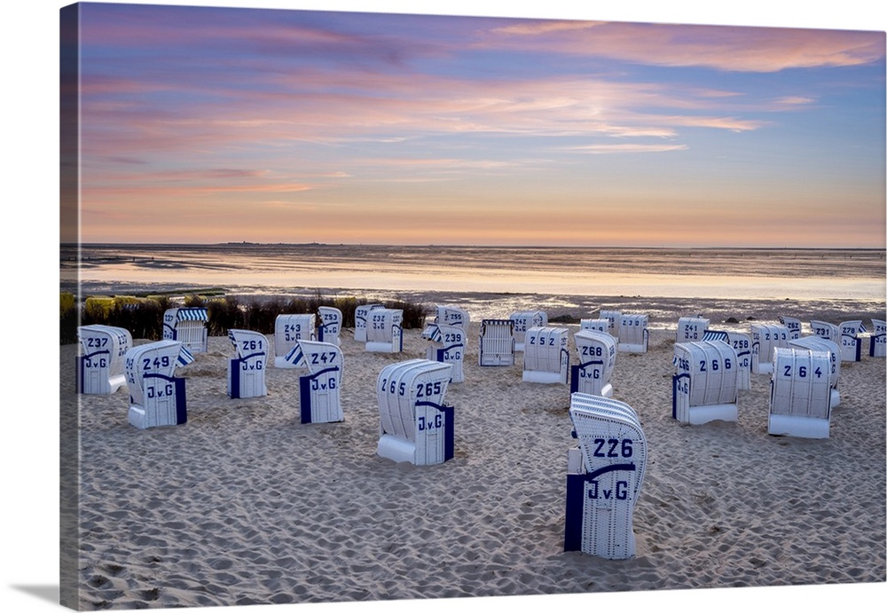 Duhnen, Cuxhaven, Lower Saxony, Germany. Strandkorb beach chairs and the Wadden Sea at sunset.