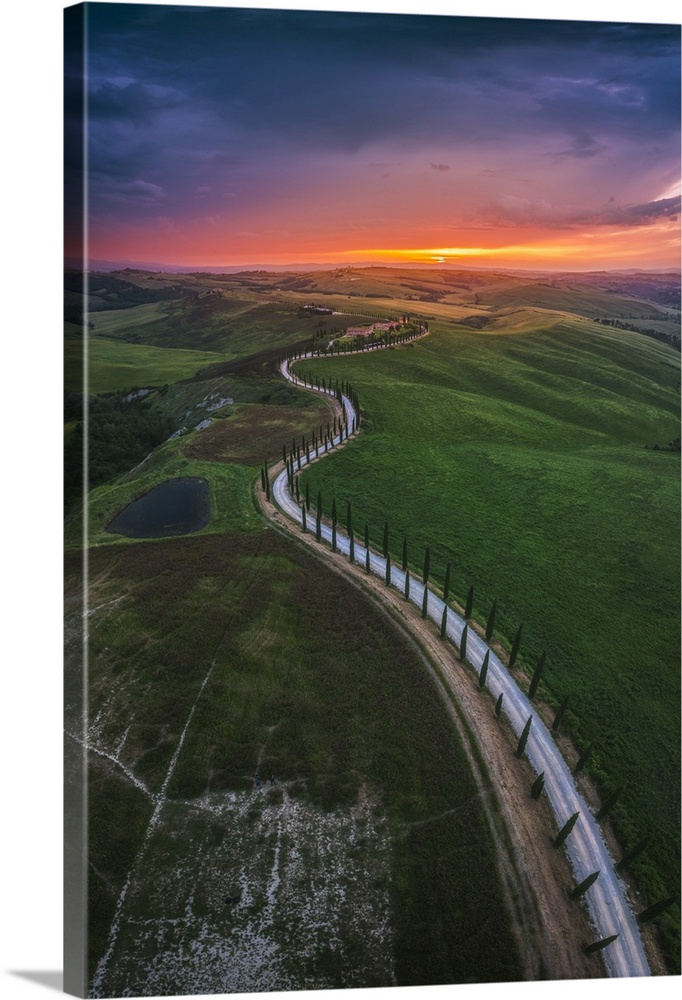 Sunset over the winding road of the Podere Baccoleno in the Crete Senesi, Tuscany, Italy.