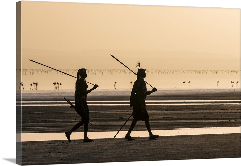 Tanzania, Lake Natron, Shompole. Two Maasai warriors walk along the shores of Lake Natron at sunrise.