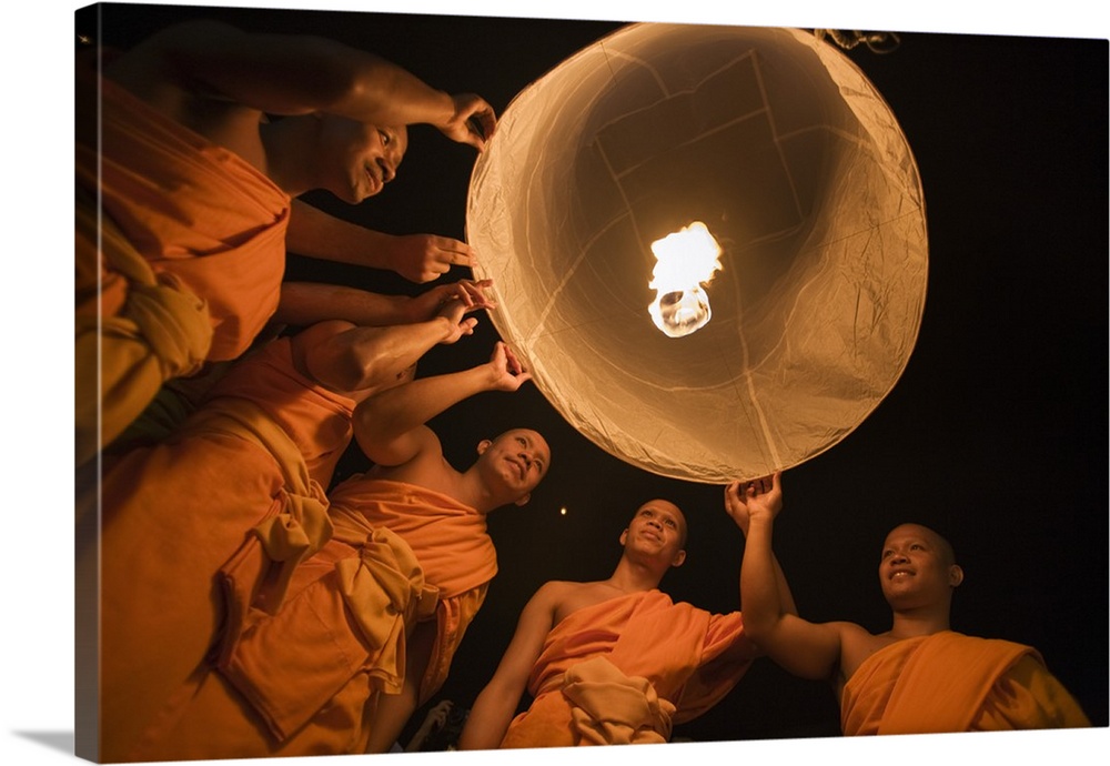 Thailand, Chiang Mai, San Sai. Monks launch a khom loi (sky lantern) during the Yi Peng festival. The ceremony is a Lanna ...