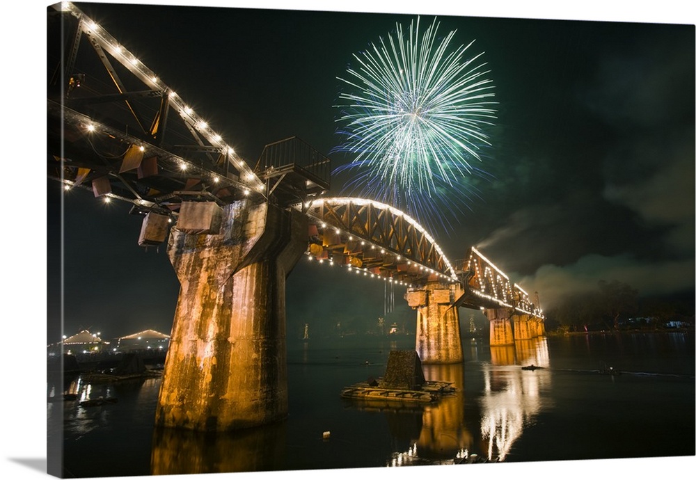 Thailand, Kanchanaburi, Kanchanaburi. Fireworks over Death Railway Bridge (also known as 'Bridge over the River Kwai') dur...