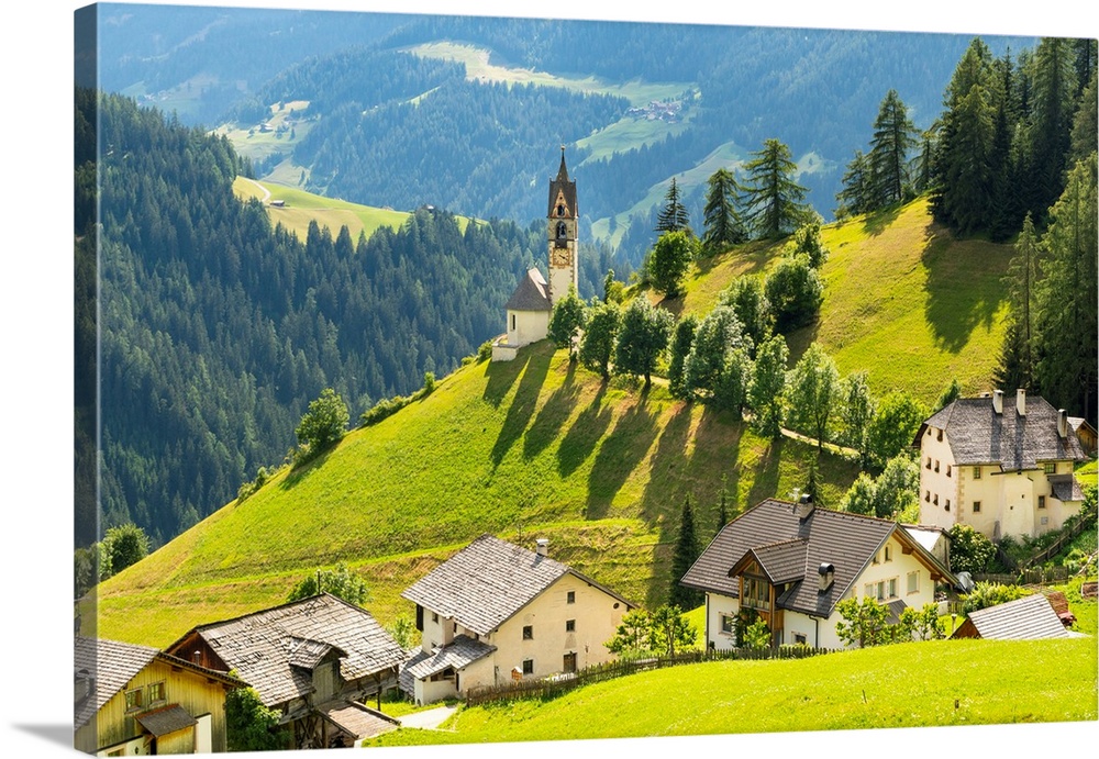 The church of La Val between threes and meadows in summer. Badia valley, Trentino Alto Adige, Italy.