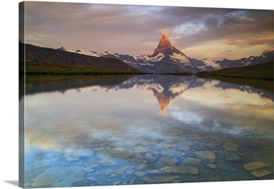 The first reflections at sunrise in the waters of Stellisee lake, Zermatt, Switzerland