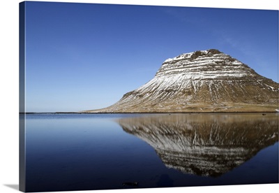 The mountain of Kirkjufell reflected in the waters of Halsvadali, Iceland