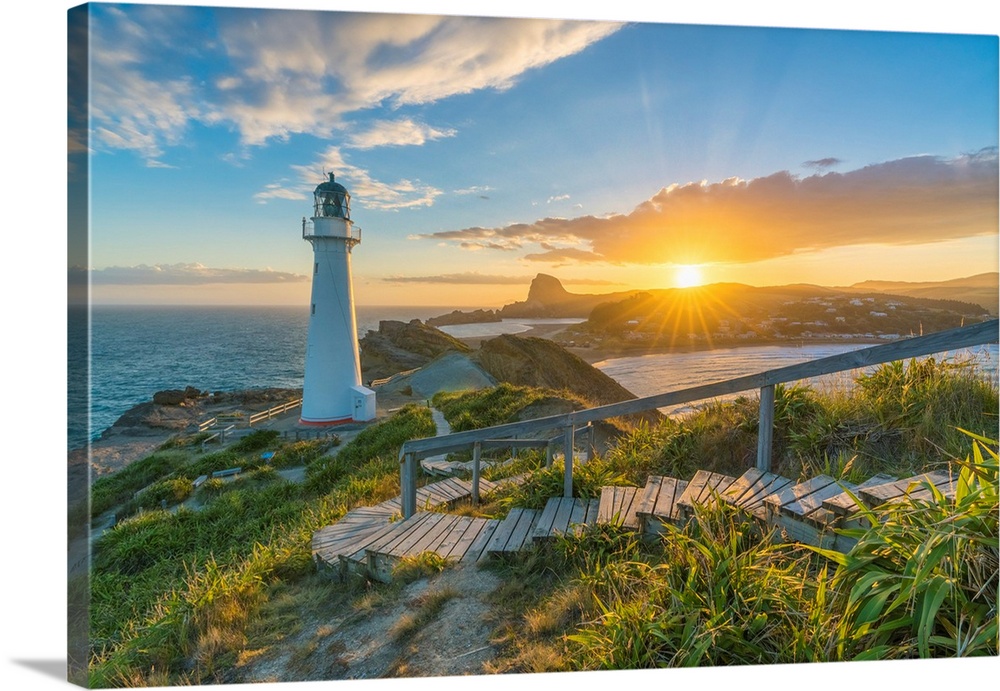 The sun is setting down behind Castle Rock and Castlepoint lighthouse. Castlepoint, Wairarapa region, North Island, New Ze...