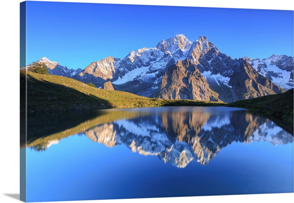 The sunlit Mont Blanc is reflected in Lac Checrouit. Checrouit Lake, Veny Valley, Courmayeur, Aosta Valley, Italy.