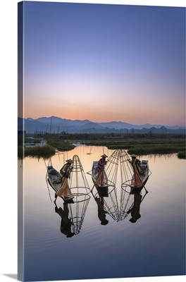 Three Fishermen Holding Typical Conical Nets On Their Boats Before Sunrise, Myanmar