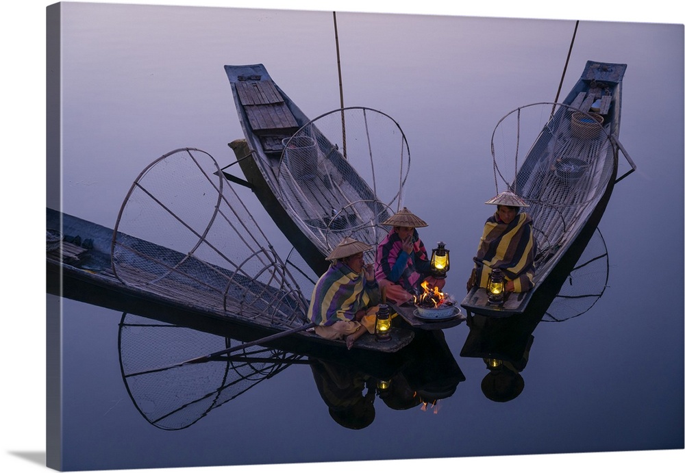 Three fishermen sitting on their boats warming up around a fire before sunrise, Lake Inle, Nyaungshwe Township, Taunggyi D...
