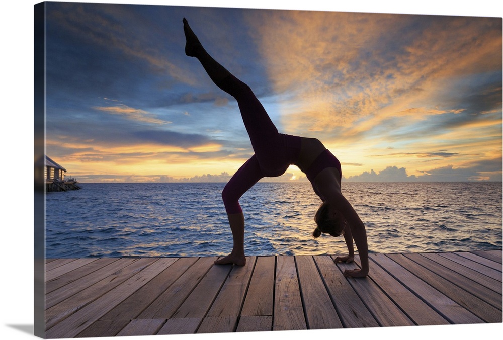 Maldives, South Ari Atoll, Thudufushi Island, Diamonds Thudufushi Resort, woman practising Yoga at sunset.