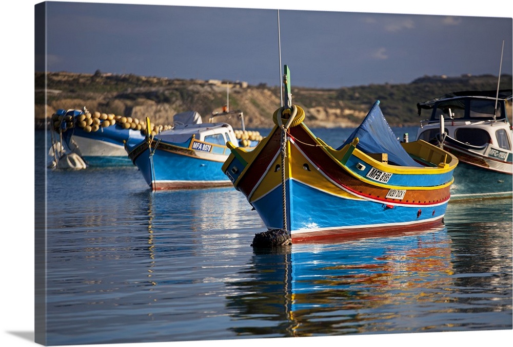 Malta, Europe, Colourful traditional Maltese boats known locally as 'luzzu' in the village of Marsaxlokk which is still ba...