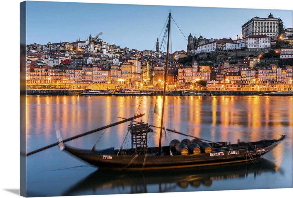Traditional Rabelo boat designed to carry wine down Douro river with city skyline behind, Porto, Portugal.