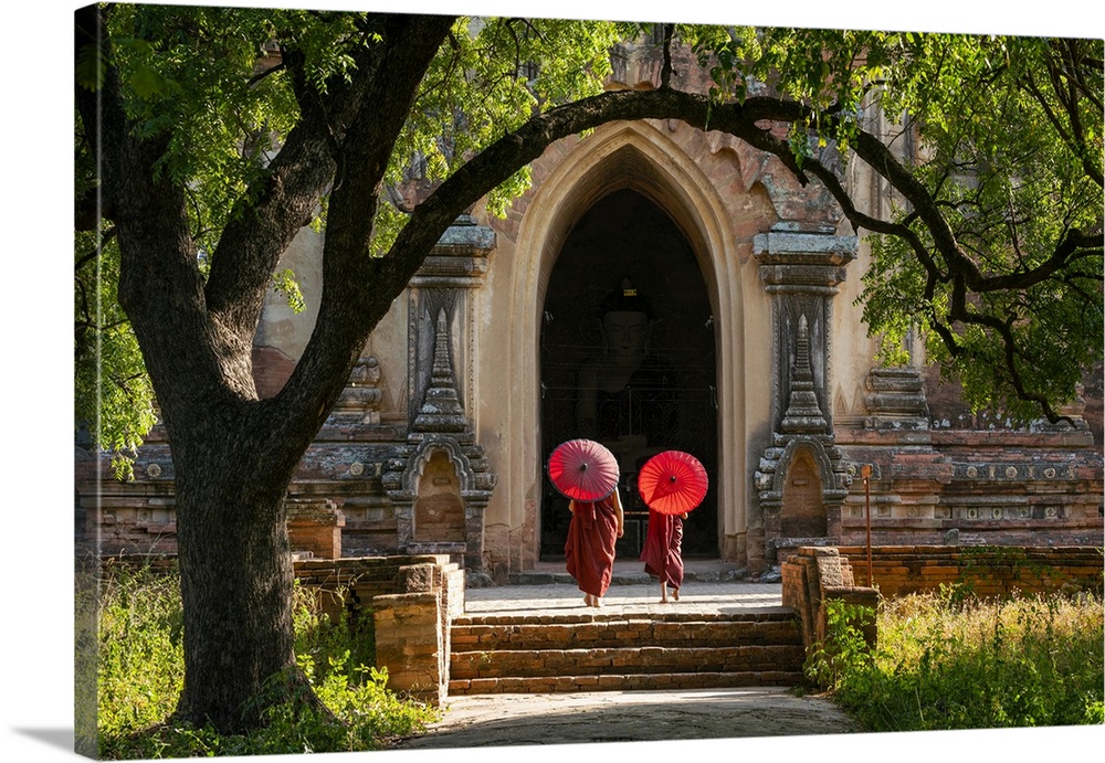 Two novice Buddhist monks with red umbrellas walking to temple, Bagan, Mandalay Region, Myanmar