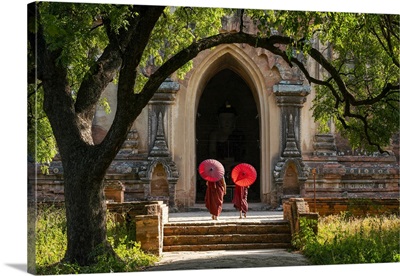 Two Buddhist Monks With Red Umbrellas Walking To Temple, Bagan, Myanmar