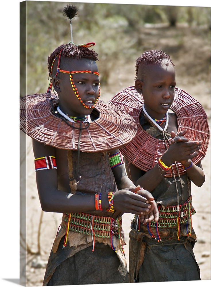Two young Pokot girls wearing traditional ornaments that denote their unmarried status. Their broad belts are made with th...