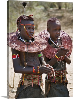 Two young Pokot girls wearing traditional ornaments that denote their unmarried status