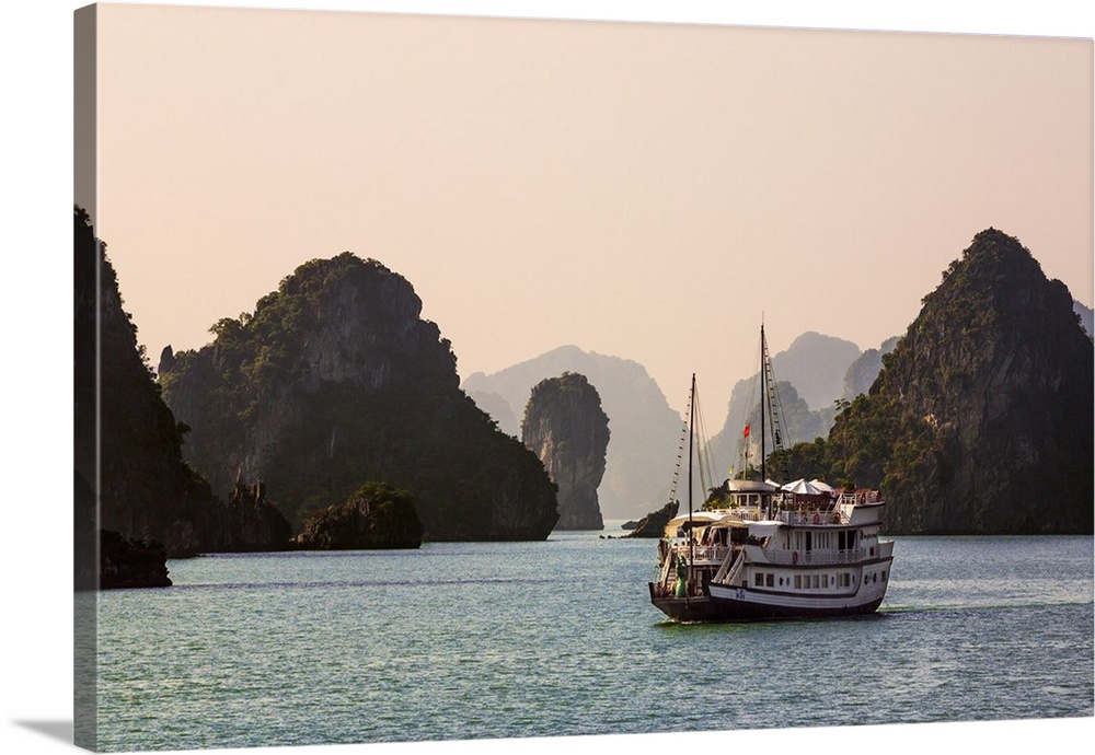 Vietnam, Quang Ninh Province, Ha Long Bay. A tourist junk cruises among the two thousand limestone Karst islands in Ha Lon...